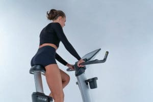 a woman is riding a stationary exercise bike