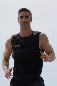 a man in a black vest is running