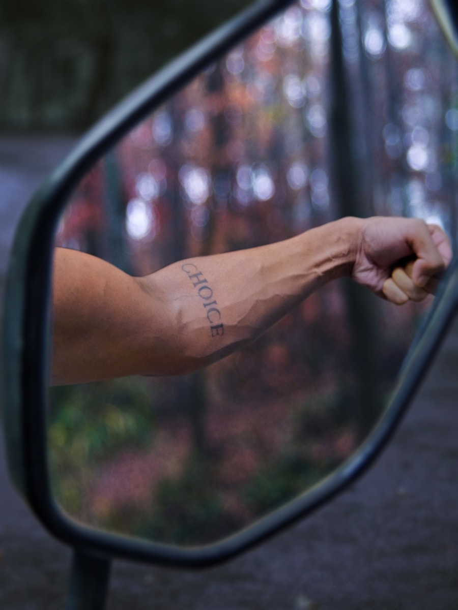 a person's arm is reflected in the side view mirror of a car