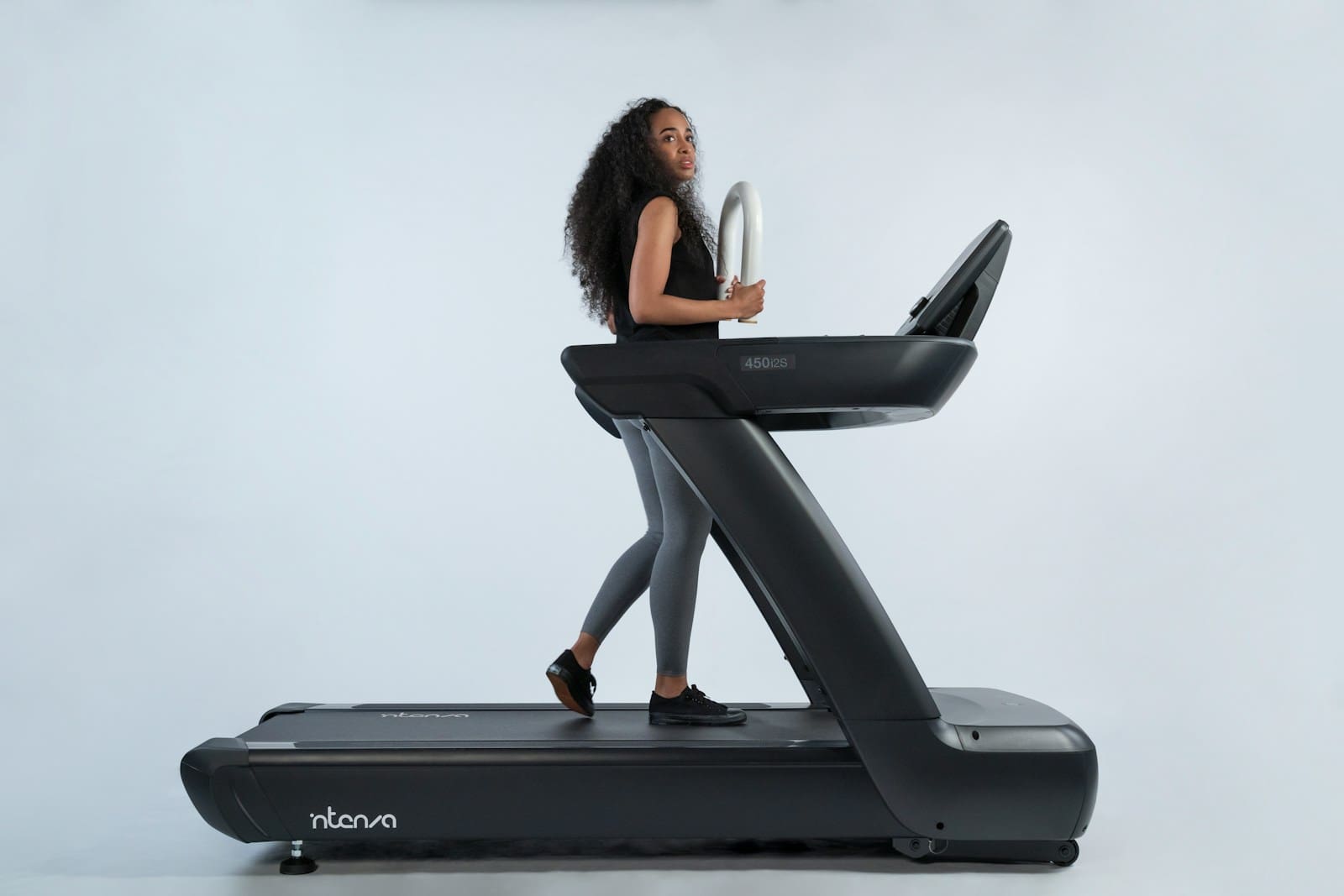 a woman is walking on a treadmill